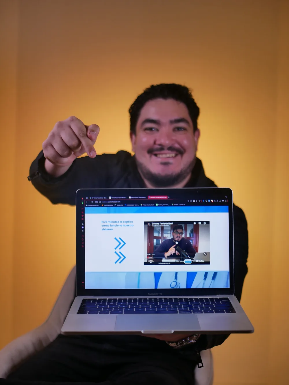 César Figuera mostrando el sistema Paciente Ideal en una laptop